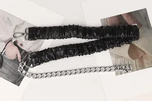 Detailansicht eines schwarzen elastischen Falten-Taillengürtels mit silberner Kette für Kleider