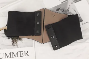 Détail d'une large ceinture corset élastique avec panneau en cuir marron et noir