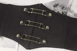 Détail de la ceinture corset élastique noire large avec trois boucles métalliques dorées élégantes
