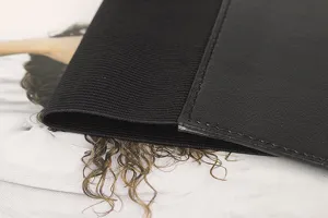Vue détaillée d'une large ceinture élastique noire avec panneau en similicuir et coutures.