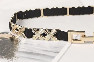 Detail view of women's thin elastic belt featuring gold flower metal links