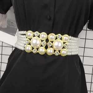 Elegant pearl elastic belt with rhinestone buckle shown on a black dress detail view