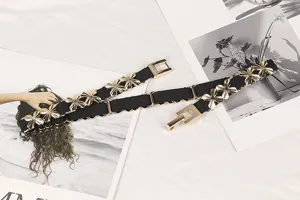 Detailed shot of an elastic belt with gold floral metal accents on a white surface.