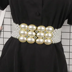 Detail of an elegant elastic belt with strands of pearls and a rhinestone buckle for dresses.