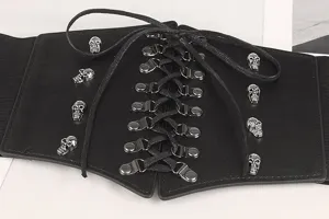 Gros plan sur une ceinture corset élastique noire avec clous tête de mort argentés