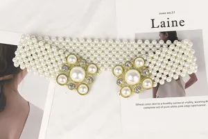 Close-up of elegant wide elastic belt with white pearls and rhinestone buckle