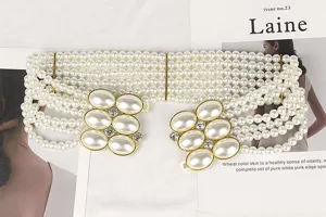 Detailed macro view of a multi-strand white pearl belt with elegant rhinestone buckle