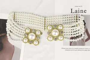 Detail of elastic multi-strand pearl waist belt with gold rhinestone flower buckle