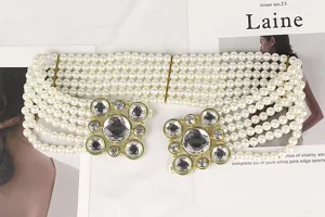 Detailed view of elegant multi-row white pearl elastic belt with luxury rhinestone buckles