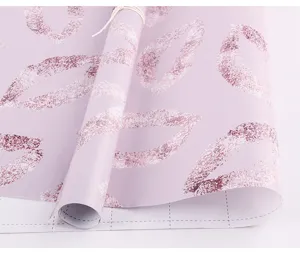 Gros plan sur un papier cadeau rose avec des motifs de lèvres pailletées et grille.