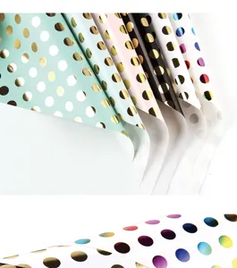 Close-up detail of metallic gold foil polka dots on premium high-quality wrapping paper