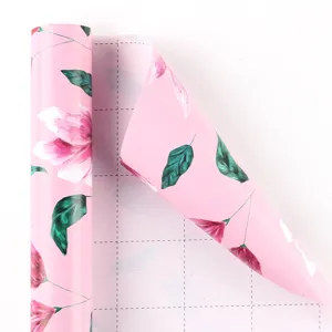 Papier cadeau rose élégant à motif floral avec une grille de découpe pratique au dos