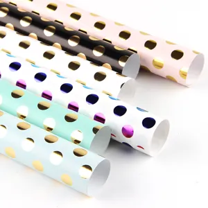 Assorted rolls of polka dot gift wrapping paper with metallic gold and rainbow foil finish