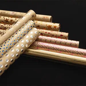 Rouleaux de papier cadeau kraft vintage avec motifs étoiles et flocons dorés décor