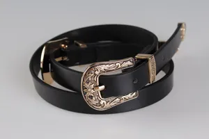 Primo piano di cintura nera vintage western con doppie fibbie dorate incise in stile Y2K