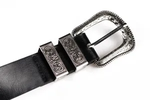 Λεπτομέρεια της vintage σκαλιστής ασημένιας αγκράφας σε μαύρη ζώνη