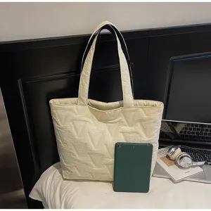 Vista detallada del bolso tote acolchado crema con comparación de tamaño de la tableta