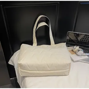 Primer plano de un bolso tote acolchado de color blanco crema con diseño de patrón en V