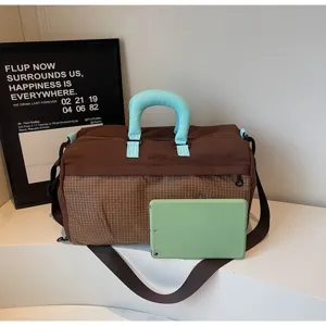 Large brown and checkered travel bag detail showing its size relative to a green tablet.