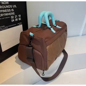 Detailed macro view showing the brown fabric texture and light blue handle of the duffel bag
