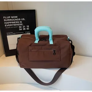 Detailed view of brown travel duffle bag with stylish contrast turquoise padded handles