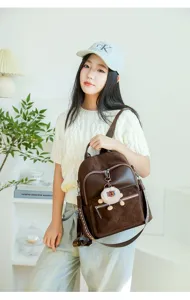 Stylish brown quilted women's backpack with cute bear pendant in a lifestyle setting