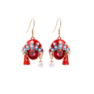 Detailed view of red Peking Opera mask earrings with pearls and crystals.