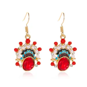 Detailed view of Peking Opera mask earrings with red crystal and gold finish