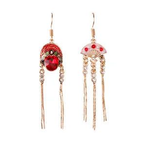 Close-up of asymmetric Chinese Peking opera mask and fan tassel earrings in red gold