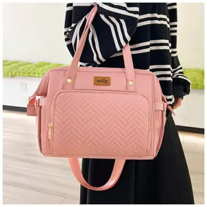 Detailaufnahme einer rosa multifunktionalen Wickeltasche mit gewebter Textur und Logo-Patch.