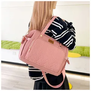 Nahaufnahme der gesteppten pinkfarbenen Wickeltasche an der Schulter des Models.