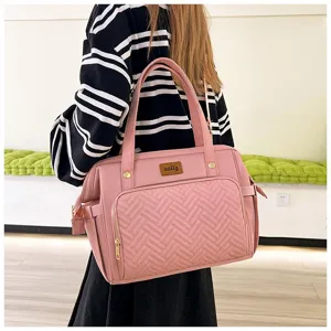 Detail einer rosa Wickeltasche mit Steppmuster, an einem Modell präsentiert
