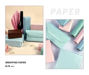 Nahaufnahme von Perlmutt-Geschenkpapier in verschiedenen Pastelltönen und Geschenkboxen