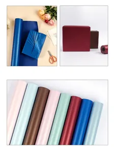 Nahaufnahme von mehrfarbigen Perlmutt-Geschenkpapierrollen und eleganten Geschenkboxen.