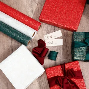 Cloth-textured gift wrapping paper rolls in festive red, green, and white holiday colors