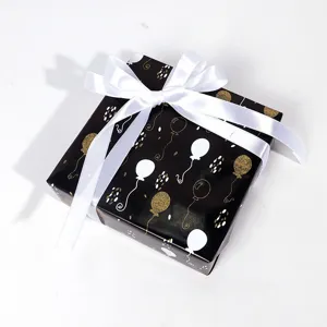 Schwarzes Geschenkpapier mit eleganten Goldfolienballons und weißen Pünktchenmuster für DIY