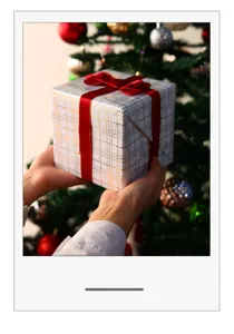 Nahaufnahme von weißem und goldfarbenem Geschenkpapier mit Karomuster und roter Schleife
