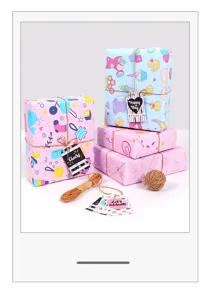Detailed view of cartoon baby gift wrapping paper used on boxes with festive gift tags.