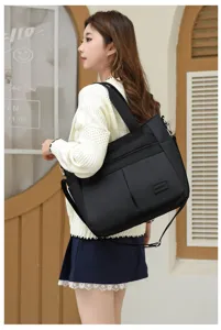 Asiatisches Model mit großer schwarzer Nylon-Tragetasche in stilvollem Außenbereich