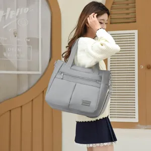 Spacious grey nylon shoulder bag for women featuring multiple pockets and top handle