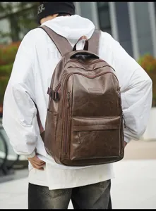 Vista trasera de un modelo masculino con una mochila de viaje retro de cuero marrón