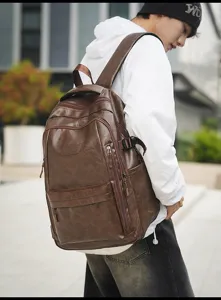 Vista detallada de una gran mochila de cuero marrón vintage en un modelo masculino