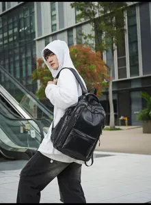 Modelo masculino con mochila negra grande de estilo retro casual en zona urbana