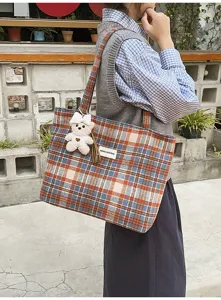 Foto de estilo de vida casual de un bolso tote de lana a cuadros con un osito pequeño