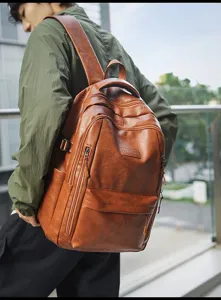 Modelo con una mochila grande de cuero marrón retro para desplazamientos urbanos.