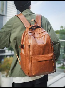 Vista trasera de una mochila grande de cuero marrón retro con bolsillos con cremallera.