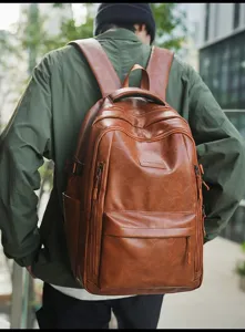 Detalle de mochila de cuero marrón vintage usada por modelo en ambiente exterior