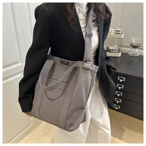 A detailed view showing the textured grey canvas material of this stylish unisex tote bag.