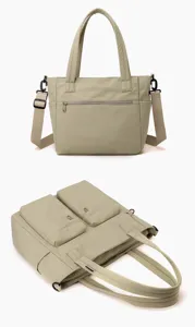Close-up detail of beige multi-pocket canvas tote bag with adjustable shoulder strap
