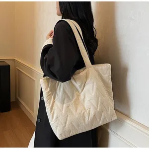 Bolso tote acolchado blanco grande con patrón de M llevado por una modelo